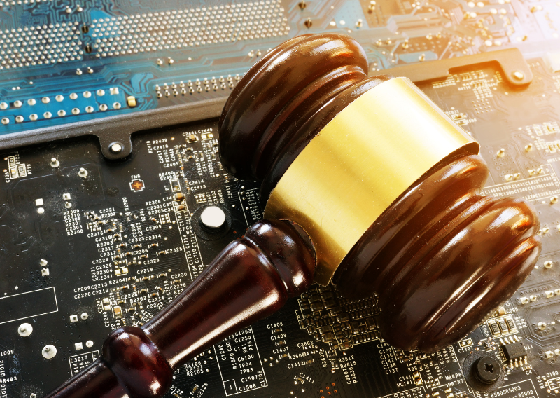 A judge’s gavel resting on a computer circuit board, symbolising regulation, compliance, and trust in a modern CFD trading platform.